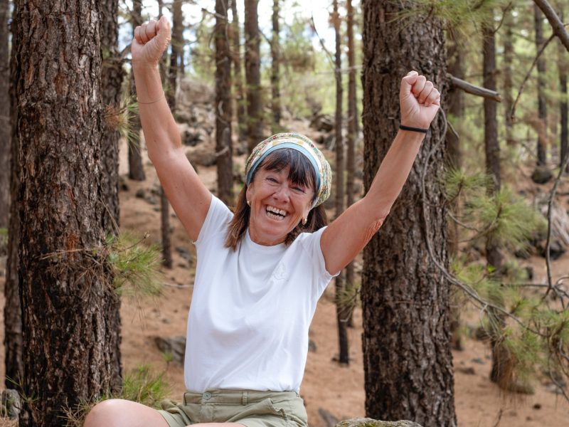 Joyful senior woman enjoying a mountain hike expressing happiness and well-being