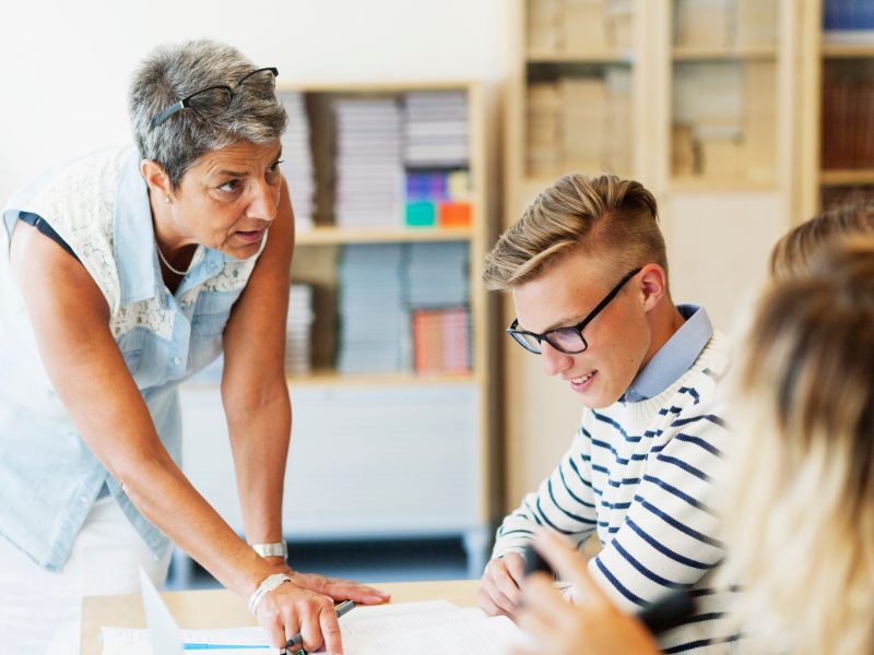 Mature teacher explaining students in classroom